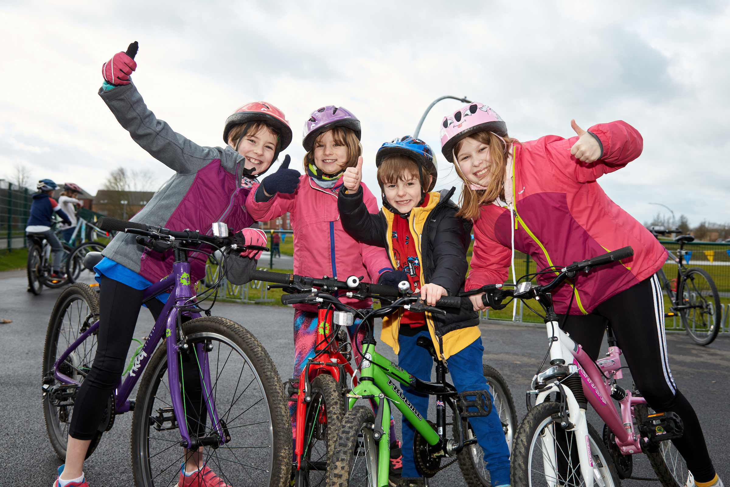 Four kids smiling on bicycles