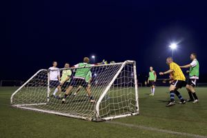 People playing football scoring a goal