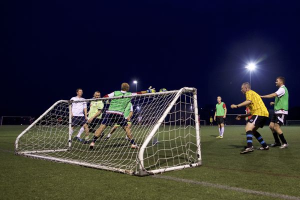 People playing football scoring a goal